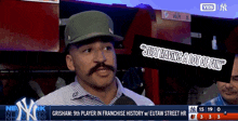 a man with a mustache is being interviewed on a tv screen