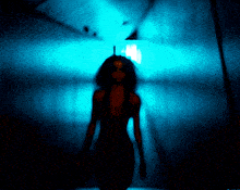 a woman in a black dress is standing in a dark room