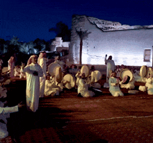 a group of people playing drums in front of a white building