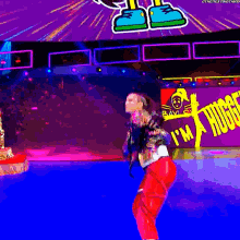 a woman is dancing in front of a sign that says i 'm a huge