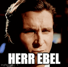 a close up of a man 's face with herr ebel written in white letters