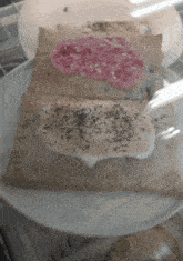 a toaster pastry with pink frosting and black sprinkles on it