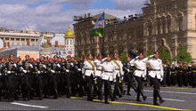 a group of soldiers marching down a street in front of a building with the word russia on it