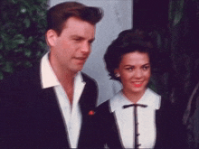 a man and a woman are standing next to each other and the woman is smiling