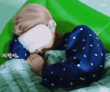 a baby is sleeping in a hospital bed with a bandage on his face .