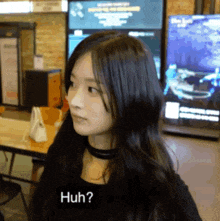 a woman with long black hair is looking at the camera with the words huh behind her