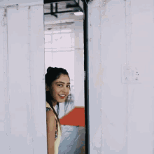 a woman stands in front of a mirror smiling