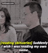 a man and a woman are sitting at a table and the man is reading a book .