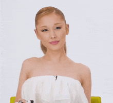 a woman wearing a white strapless top looks surprised