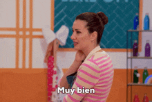 a woman in a striped shirt says muy bien in spanish