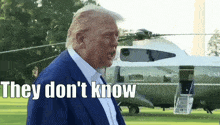 donald trump stands in front of a helicopter that says uni on it