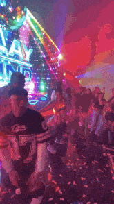 a man wearing a shirt with the number 77 on it is dancing at a party