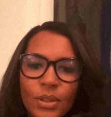 a close up of a woman wearing glasses making a face .