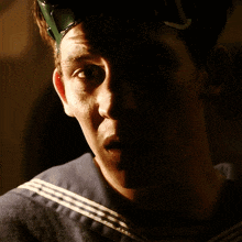 a close up of a man 's face with a helmet on