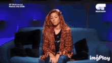 a woman sits on a blue couch with her eyes closed and a ct redfusion logo behind her