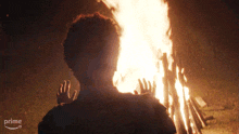 a person standing in front of a fire with a prime logo in the corner
