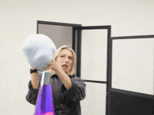 a woman wearing glasses is throwing a blue pillow