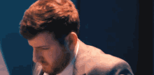 a man in a suit and tie is looking at something