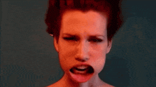 a woman with red hair making a funny face with her mouth open