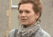 a woman is wearing a scarf and a sweater and says `` ti 'm o ddifri ? ''