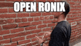 a man is standing in front of a brick wall and says open ronix