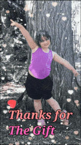 a little girl in a purple tank top stands next to a tree with the words thanks for the gift written below her