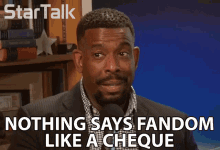 a man talking into a microphone with nothing says fandom like a cheque