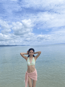 a woman in a bikini stands in the water