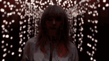 a woman with red hair is standing in front of a wall of lights