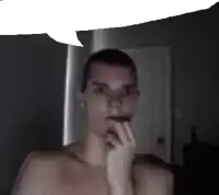 a man without a shirt is holding his hand to his chin in a dark room