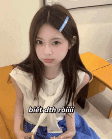 a girl wearing a white shirt and a blue plaid skirt with the words biết dth roiiii on the bottom right