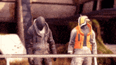 two soldiers are standing next to each other and one is wearing an orange vest that says ' i 'm ' on it