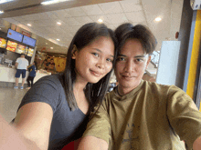 a man and a woman are posing for a picture in front of a mcdonald 's sign