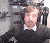 a man wearing headphones looks surprised in front of a display case with toys on it