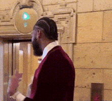 a man in a red suit and white shirt is standing in front of a green light .