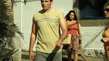 a man and a woman are walking down a sidewalk