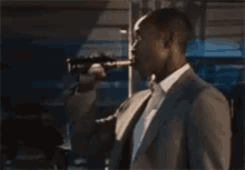 a man in a suit is holding a gun in his hand