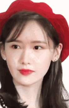 a close up of a woman wearing a red beret and red lipstick .