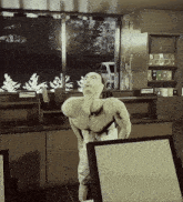 a man without a shirt is standing in front of a window in a room