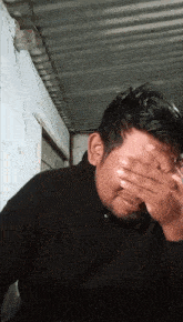 a man is covering his face with his hand
