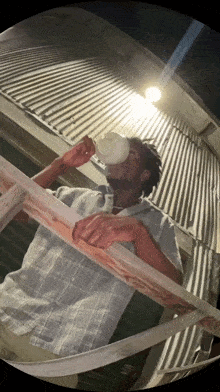 a man is drinking from a white bottle