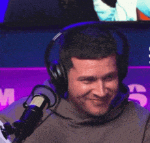 a man wearing headphones is covering his face with his hands
