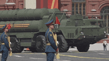 two soldiers stand in front of a military vehicle with the letter ii on it