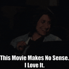 a woman sitting in a dark room with the words " this movie makes no sense i love it " on the bottom
