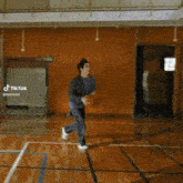 a man is dribbling a basketball on a court in a gym .