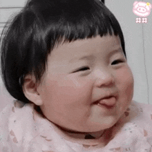 a baby is making a funny face with his tongue sticking out .