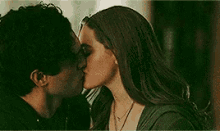 a man and woman are kissing in a dark room .