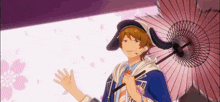 a man in a hat is holding an umbrella in front of a pink background