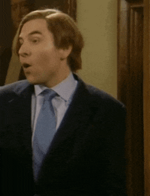 a man in a suit and tie looks surprised