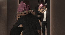 a woman with pink hair is hugging a man
